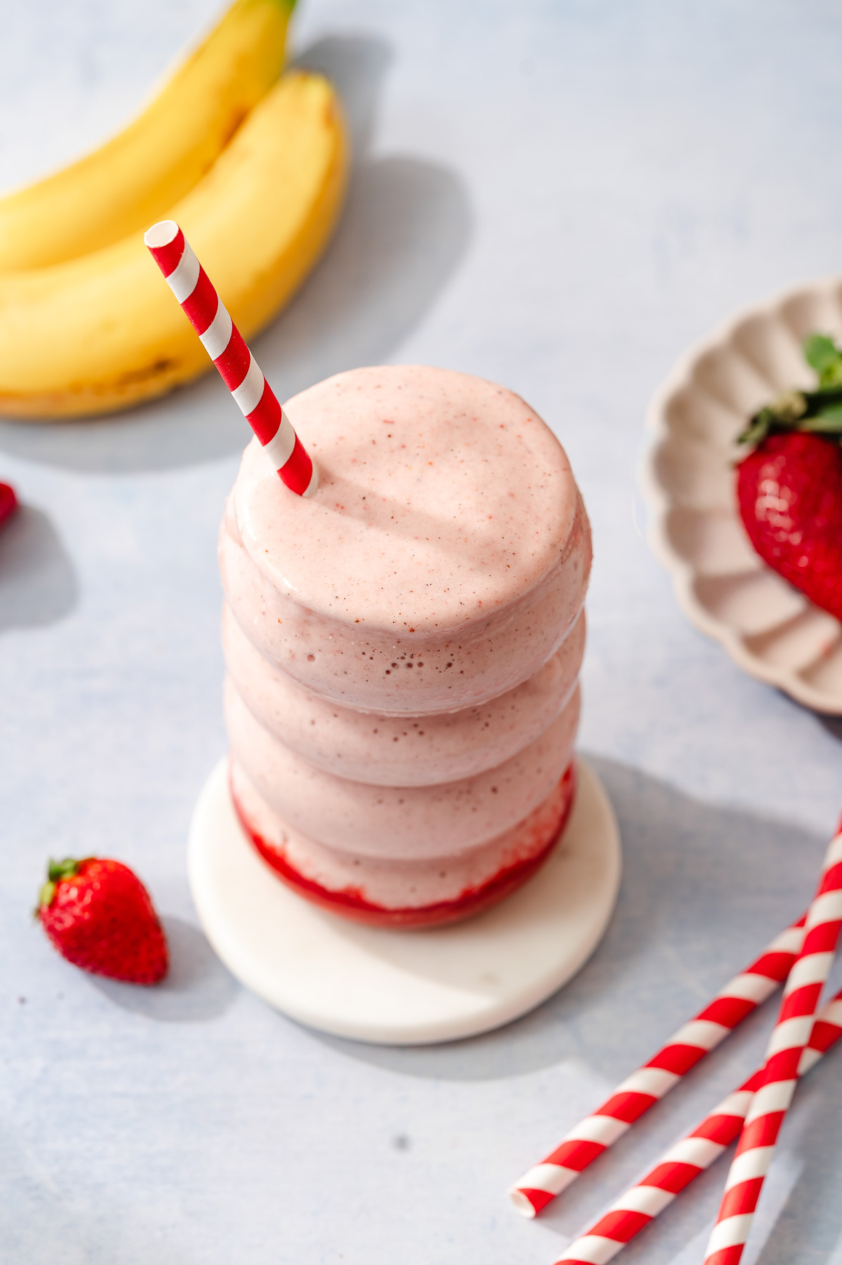 Creamy strawberry protein shake in a glass with a straw