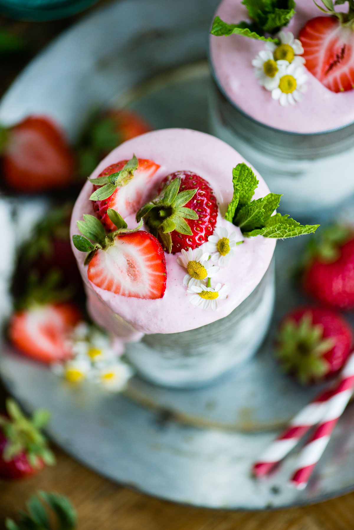 Overhead image of a strawberry vegan milkshake garnished with fresh sliced strawberries.
