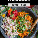 Gray bowl of Sweet Potato Noodles topped with fresh herbs, vegan coleslaw, and whole strawberries.