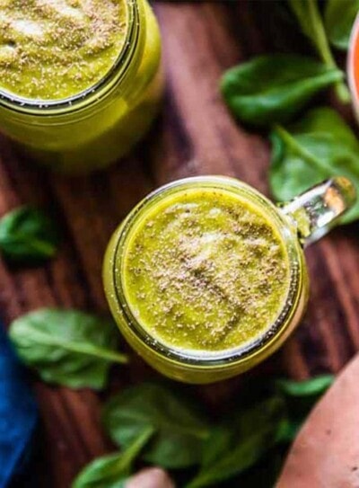 2 glass mugs of green sweet potato smoothie topped with cinnamon.