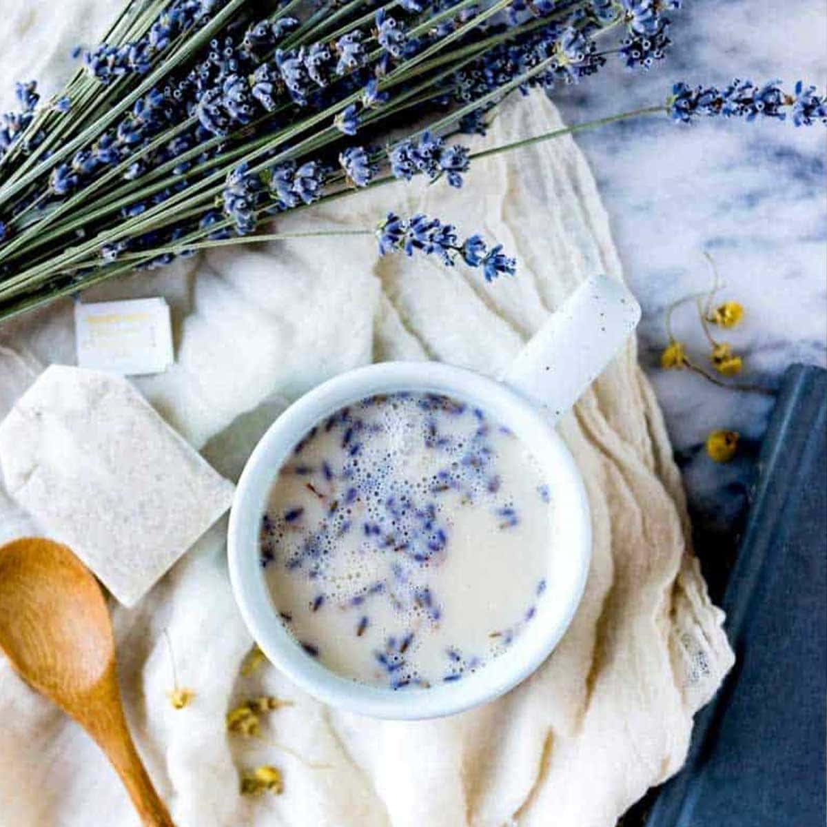 lavender tea in a white mug surrounded by lavender buds.