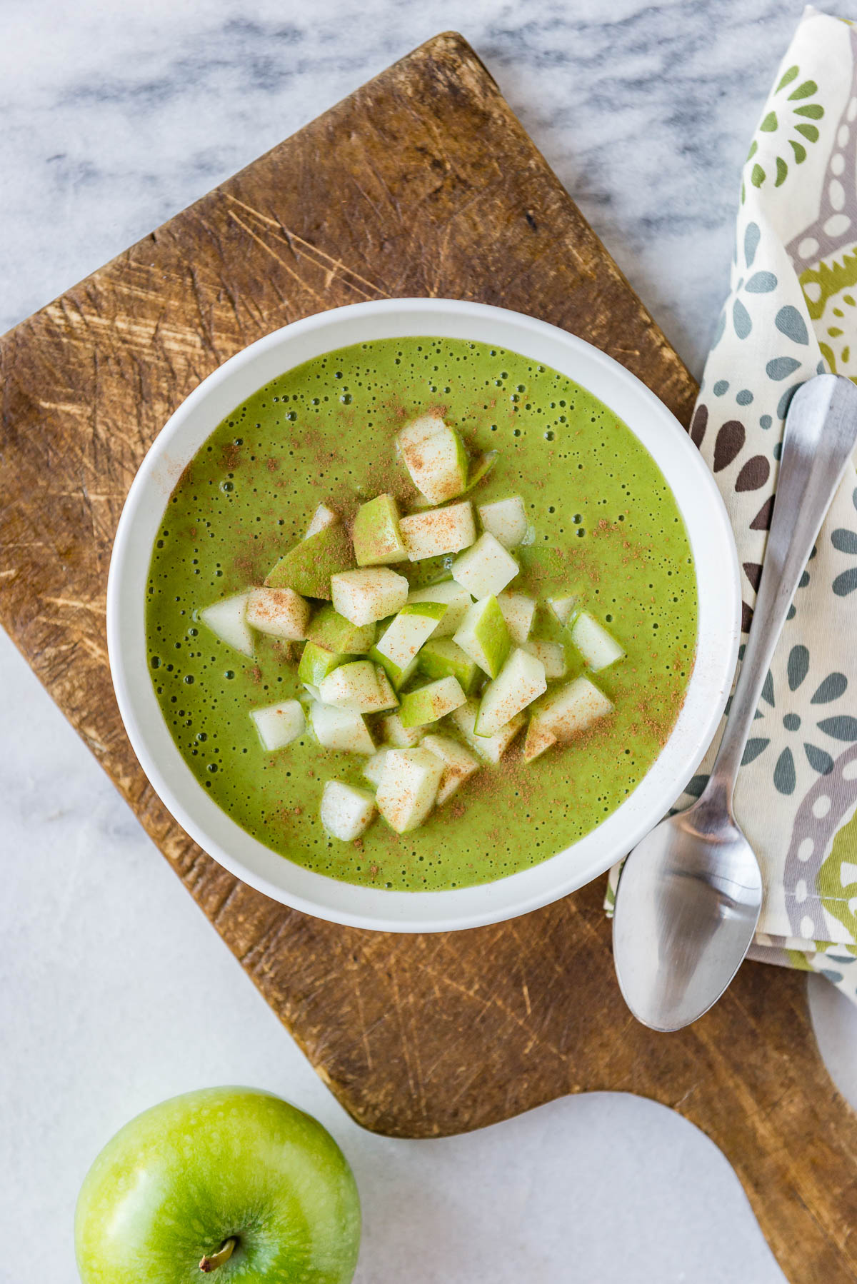 thick smoothie bowl recipe with apples in a white bowl.