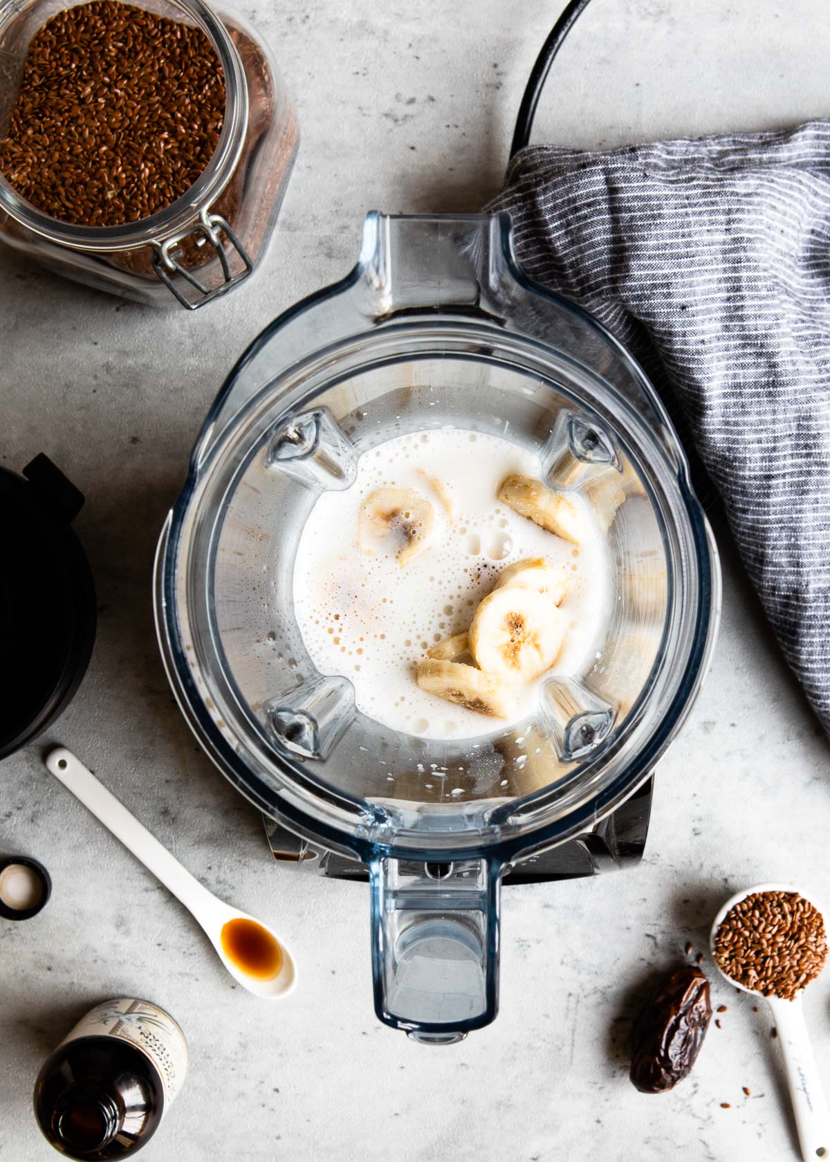 A blender container filled with almond milk and banana