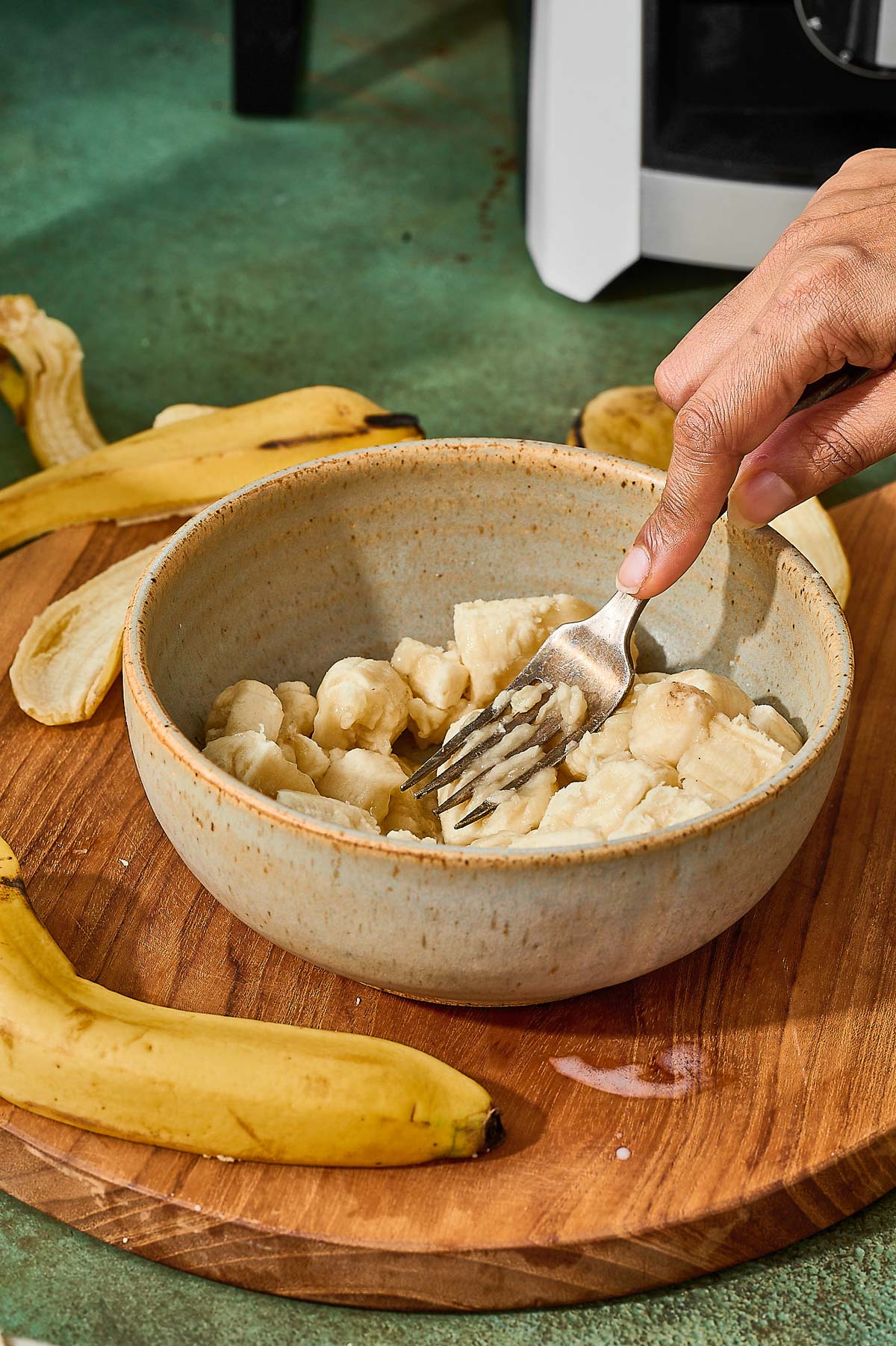 Mashing ripe bananas in a bowl with a fork