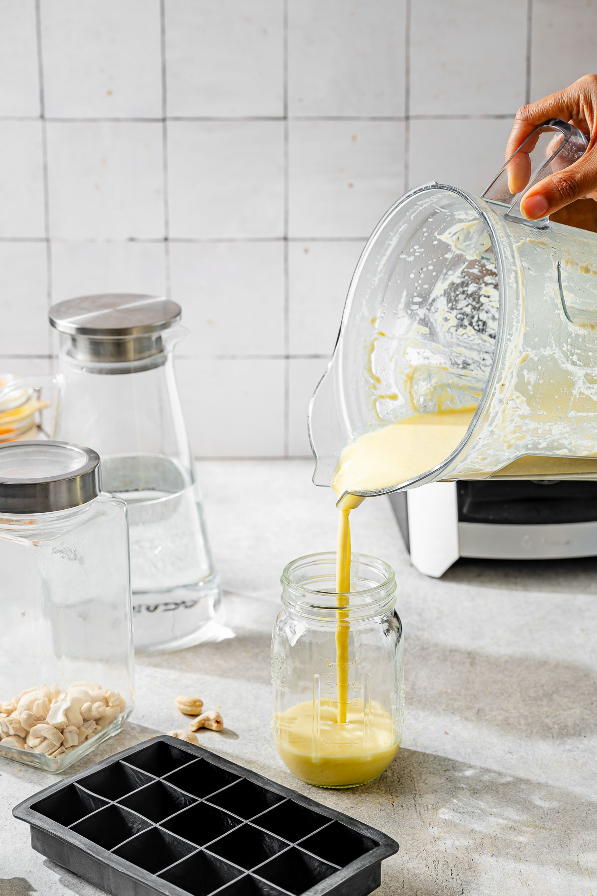 Pouring the blended vegan butter mixture from a blender