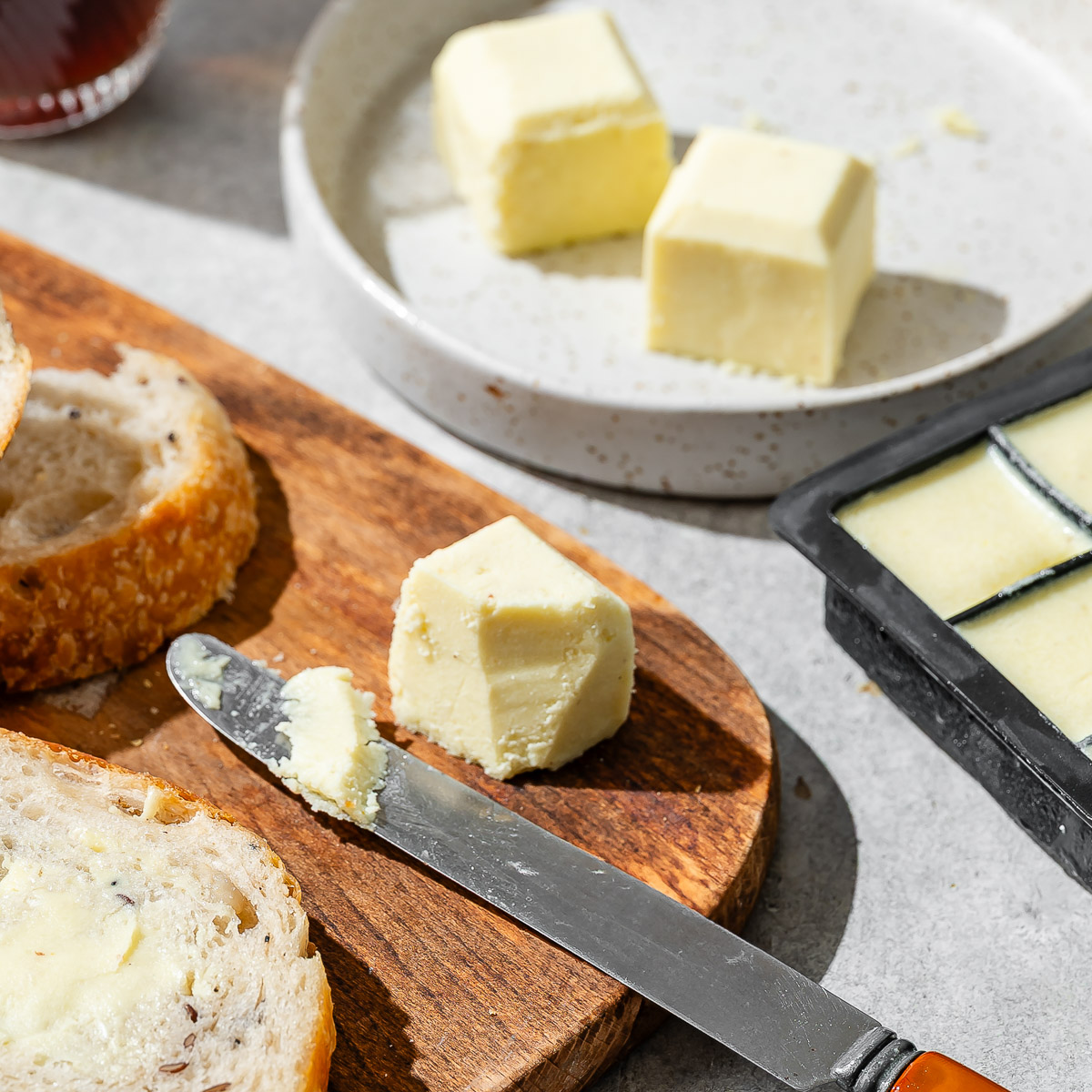 Two cubes of homemade vegan butter on a ceramic plate
