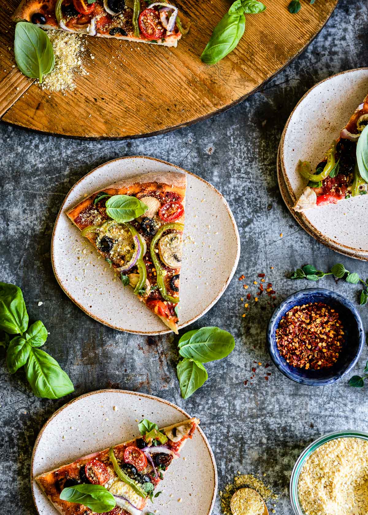 Slices of vegan pizza on white ceramic plates