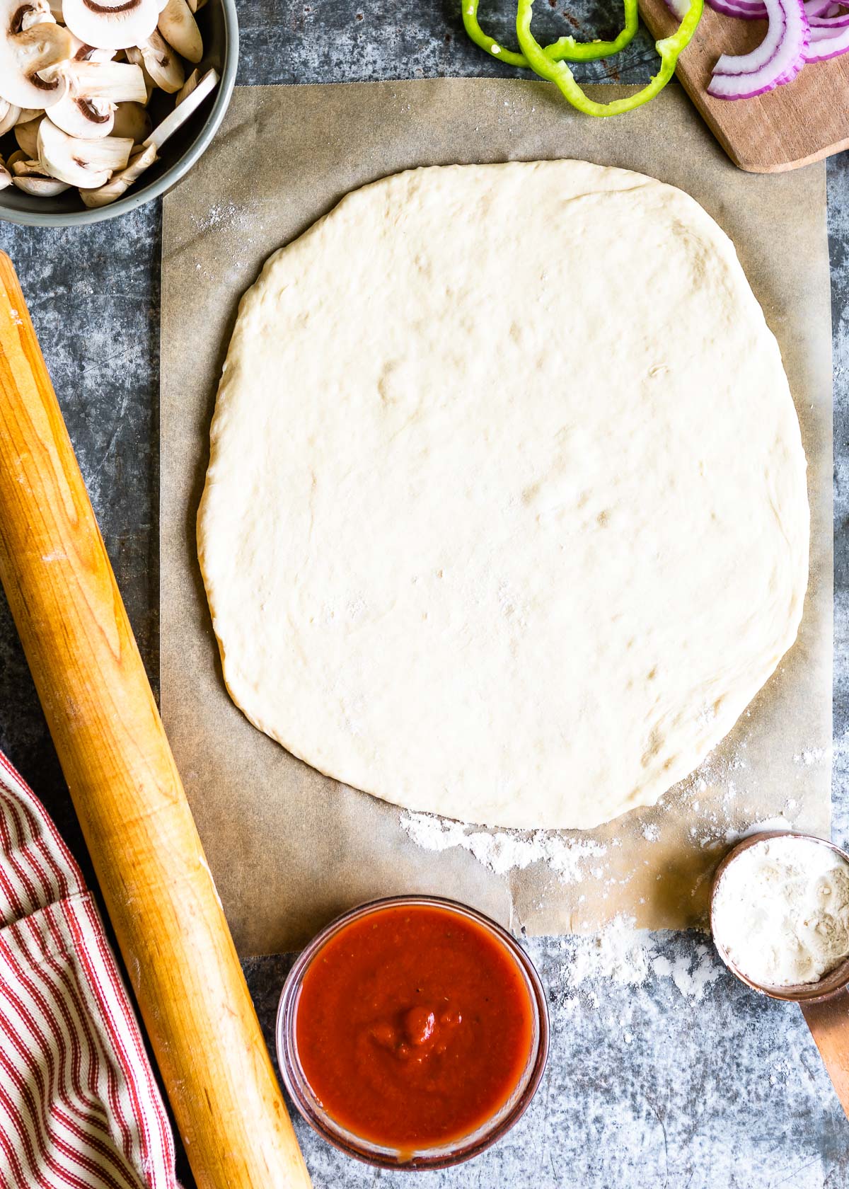 Pizza dough rolled out on a piece of parchment paper 