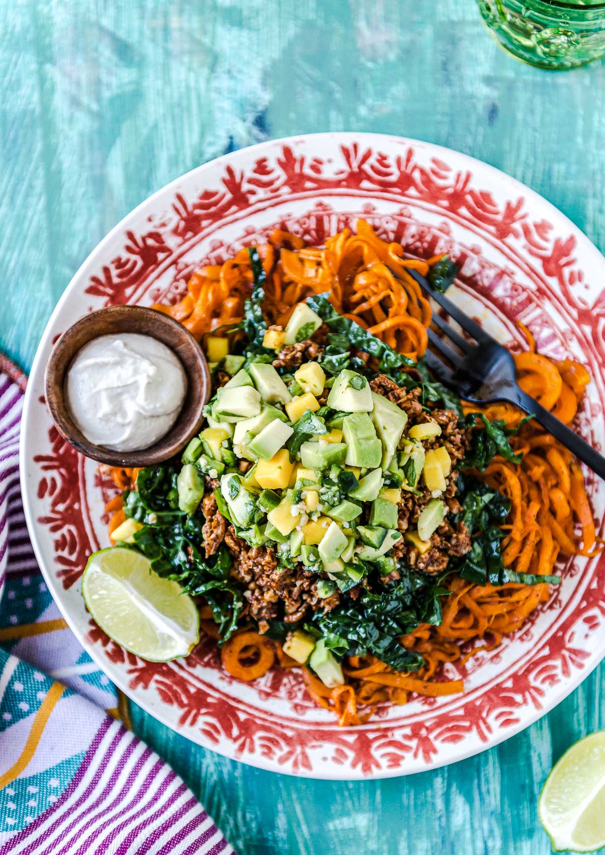 Delicious salad loaded with kale, sweet potato noodles, mango salsa, and walnut "meat."