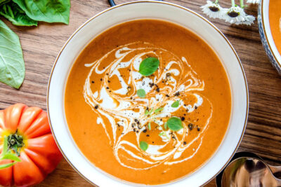 Vegan tomato soup in a bowl with a swirl of cashew cream