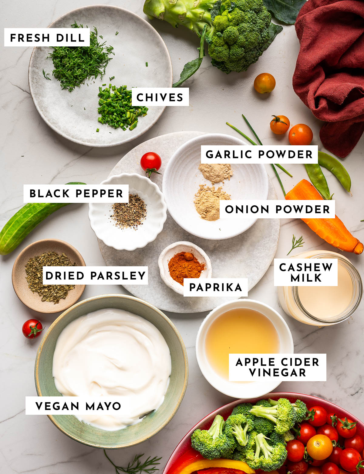 Ingredients for vegan ranch dip in bowls on marble countertop.