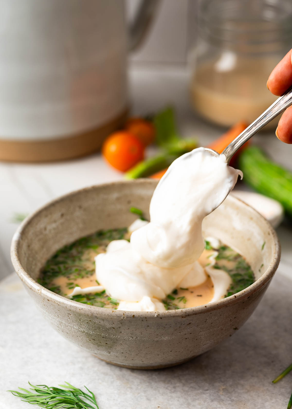 Adding a spoonful of vegan mayo to the vegan ranch dip mixture. 