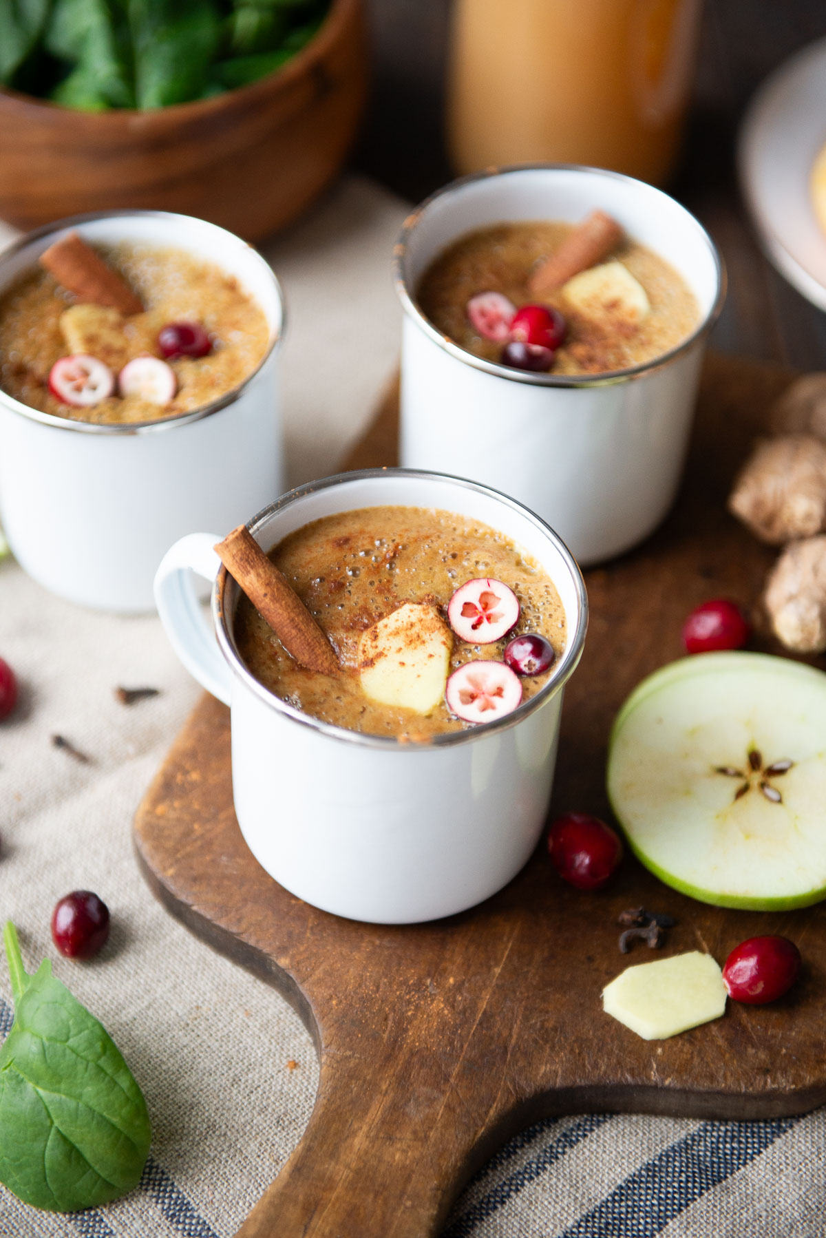 Three white mugs of warm wassail drink.