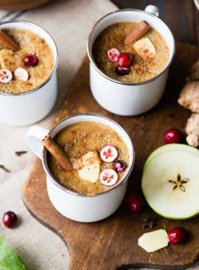 Three white mugs of warm wassail drink.
