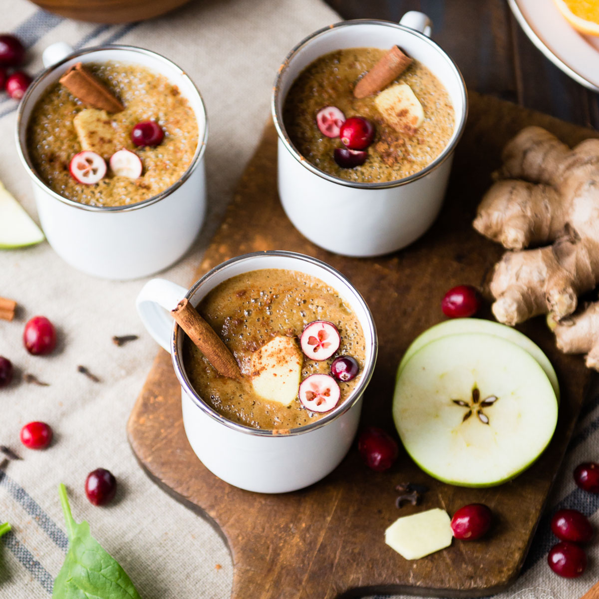 Three white mugs of warm wassail drink.