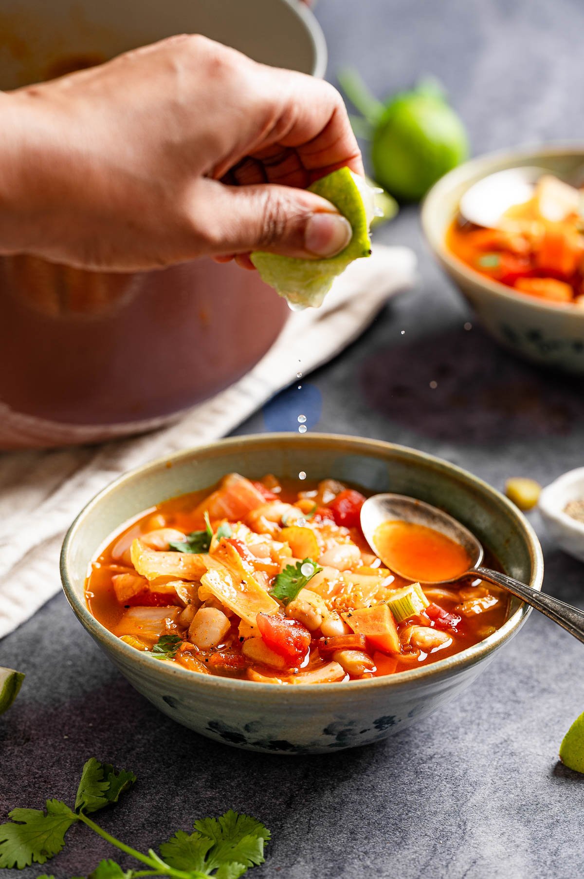 A person squeezing lime over weight loss cabbage soup