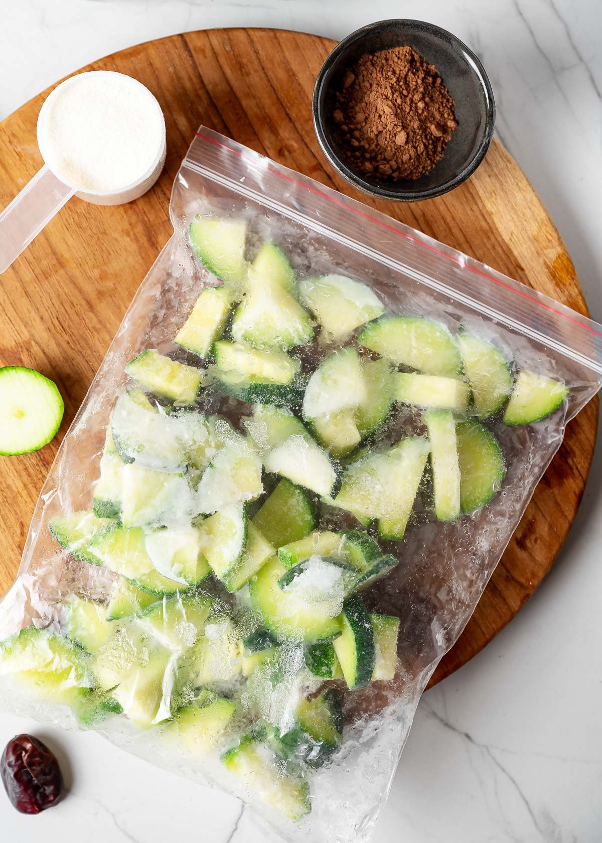 A bag of chopped frozen zucchini, cacao powder, a date and cashew milk
