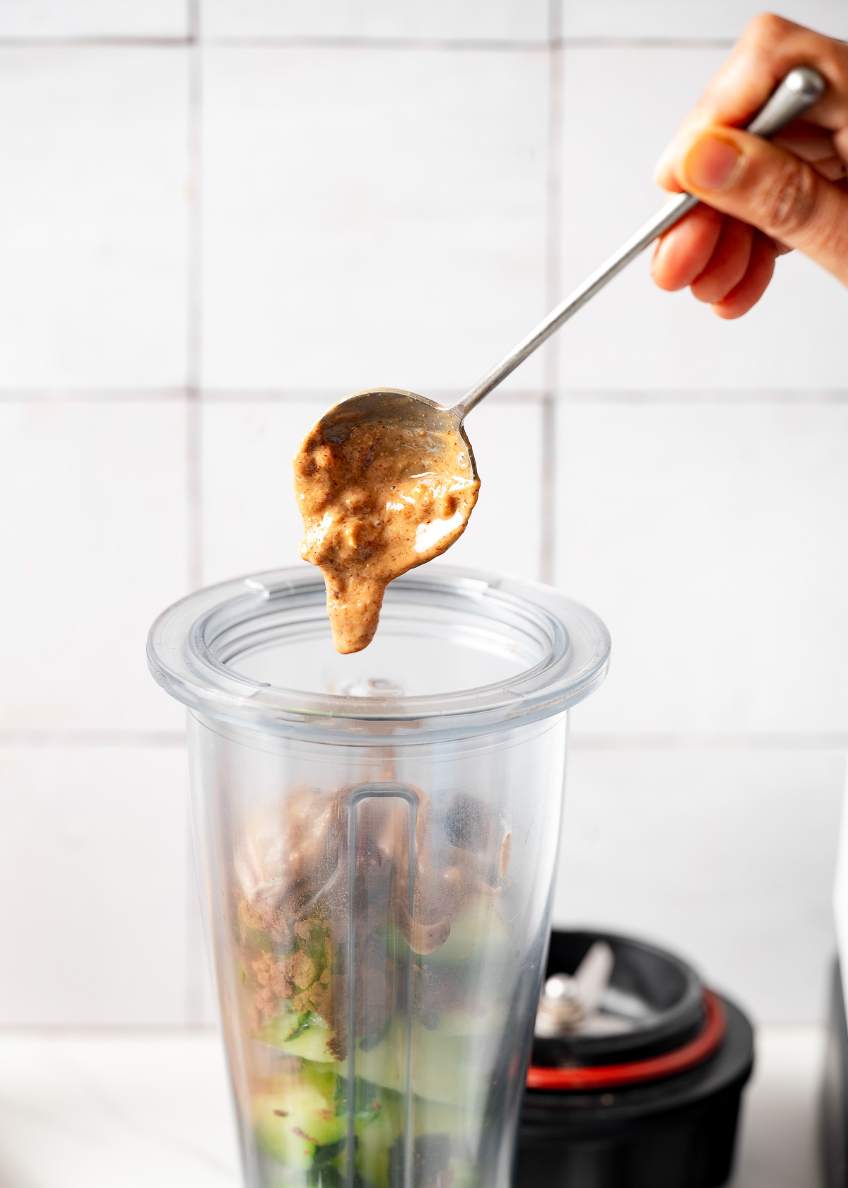 A person adding a spoonful of almond butter 