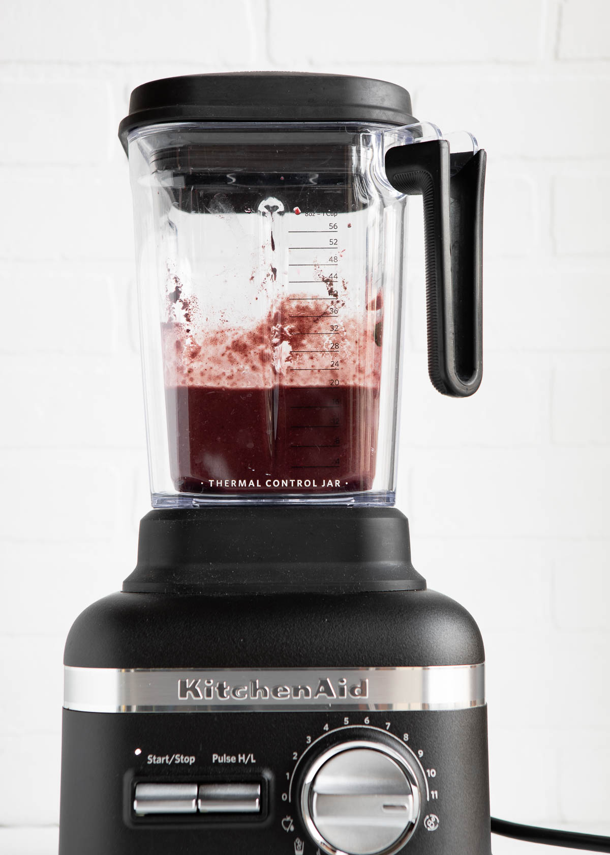 KitchenAid blender with deep red blended smoothie inside.