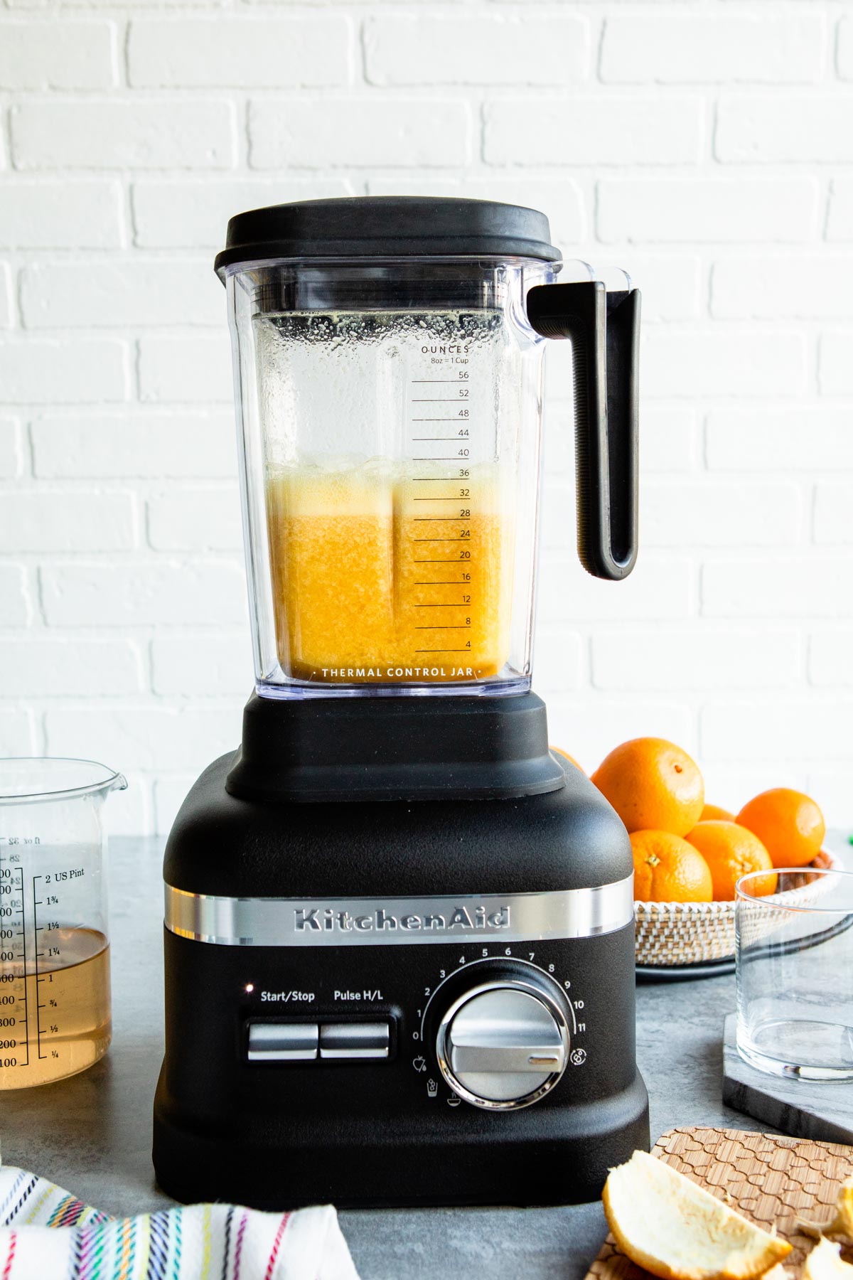 KitchenAid blender with orange beverage in it, freshly blended.