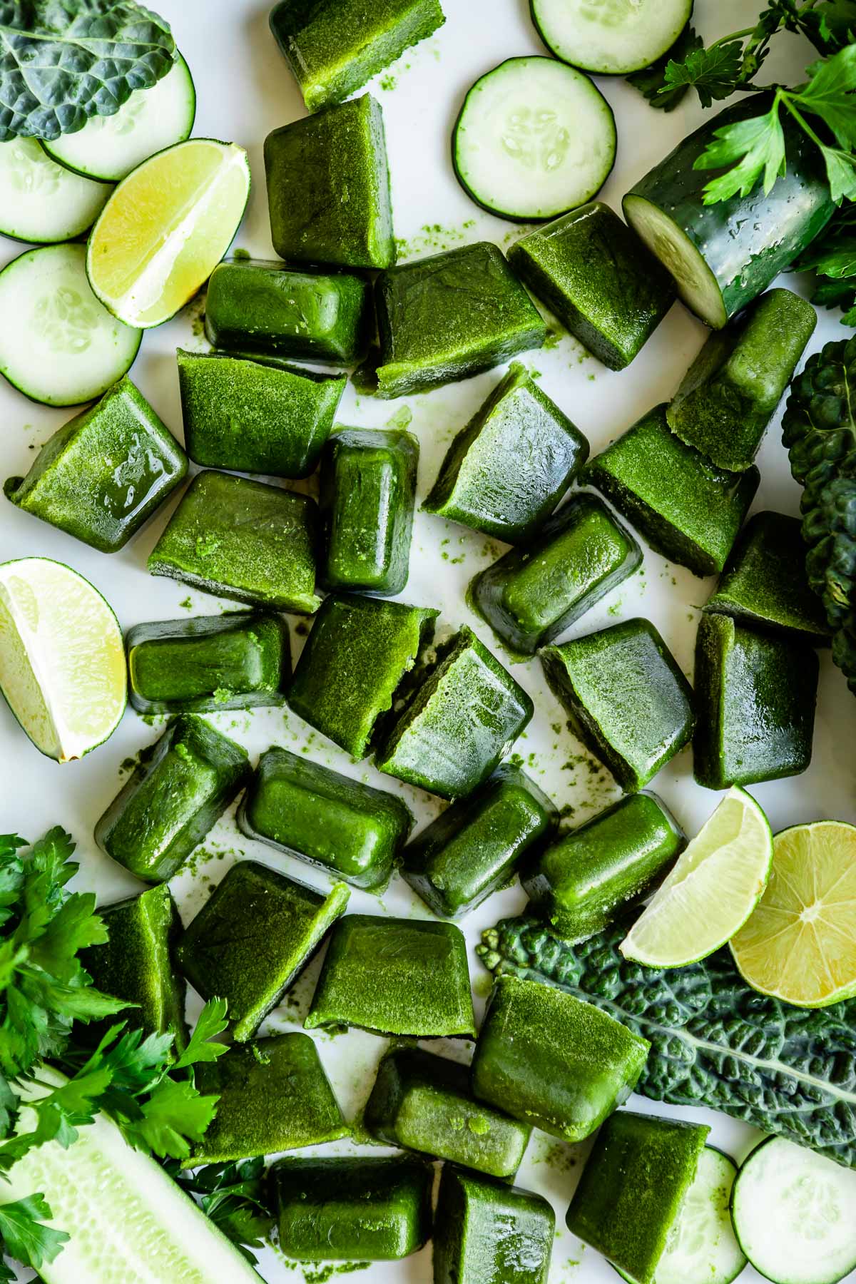 Alkaline smoothie cubes scattered on a counter, surrounded by fresh ingredients.