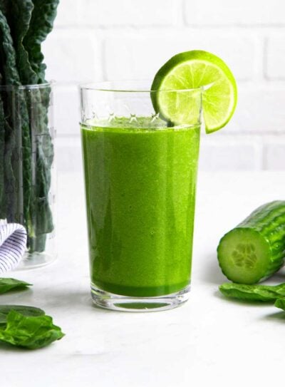 Alkaline smoothie in a tall glass with a lime wedge.