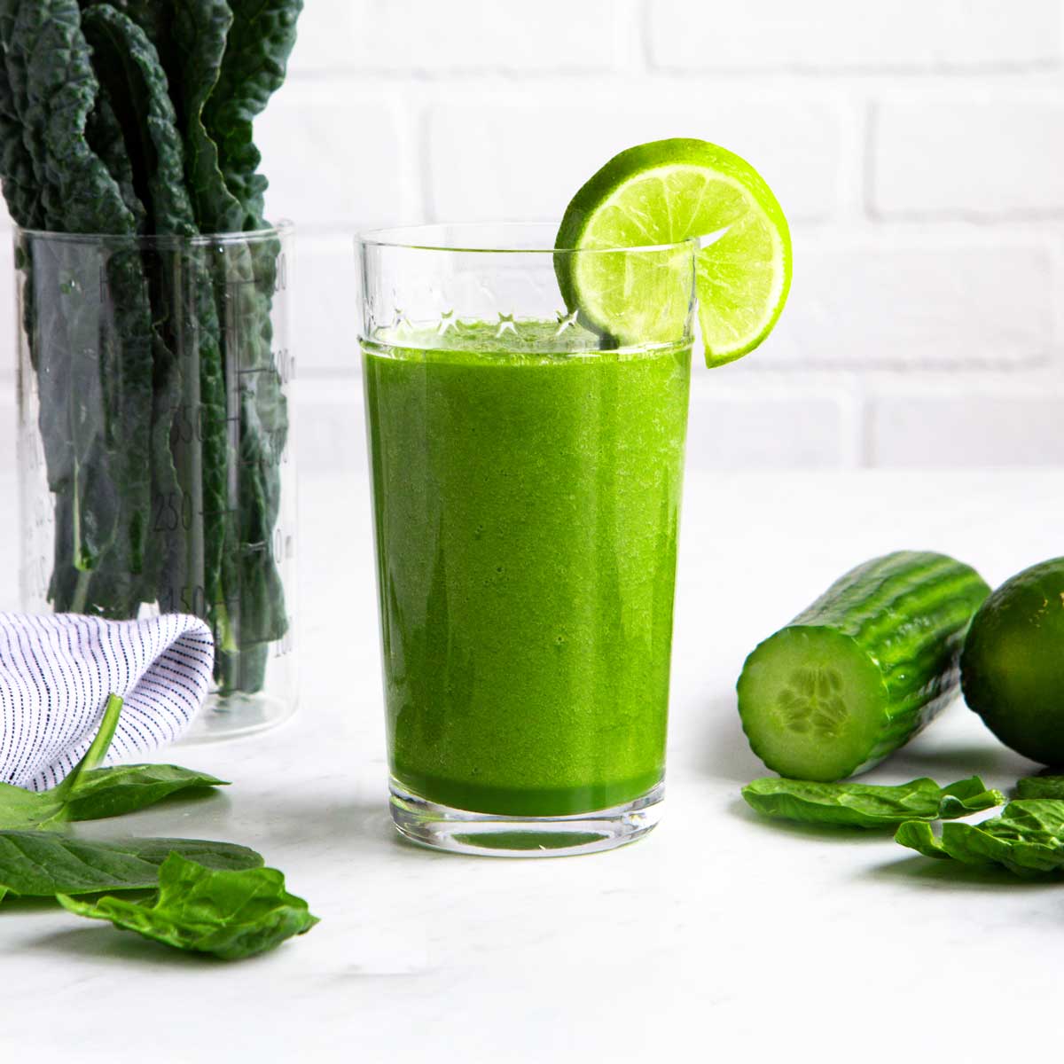 Alkaline smoothie in a tall glass with a lime wedge.