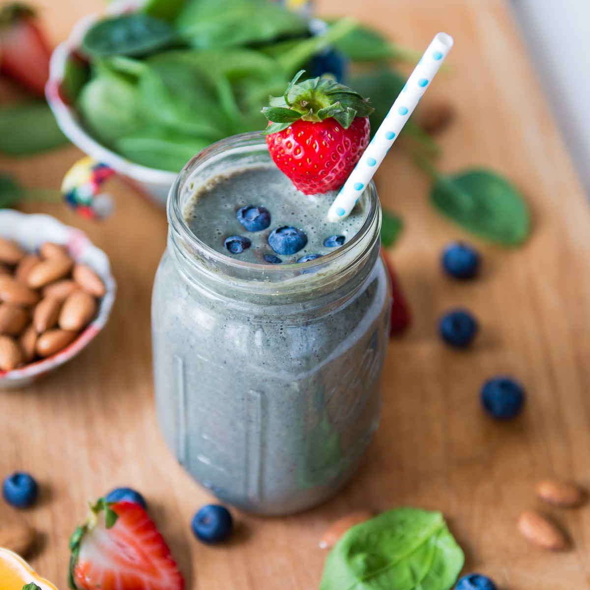 A creamy almond milk smoothie with blueberries and a strawberry on top