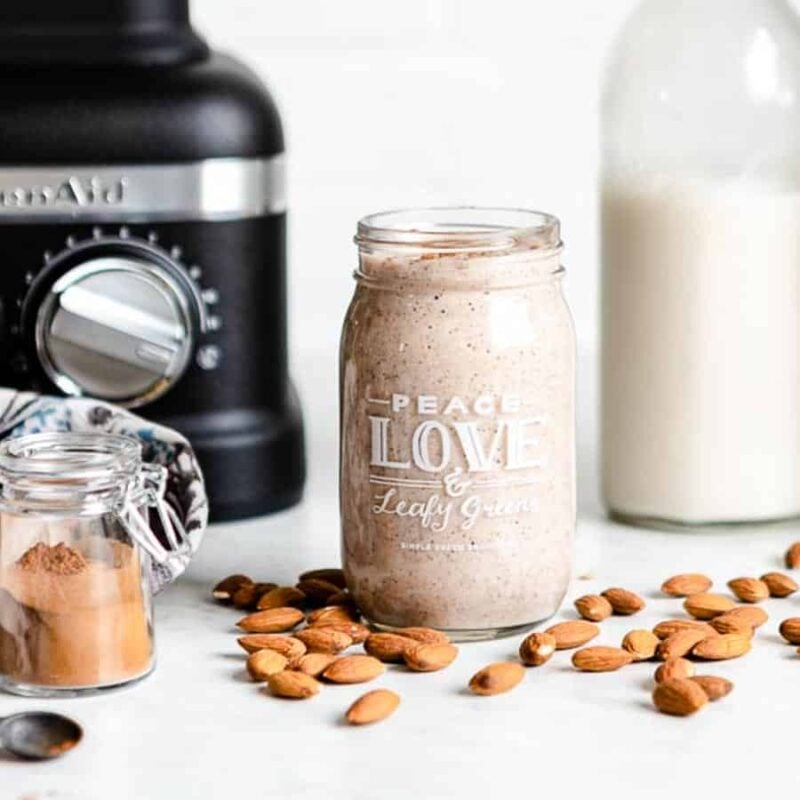 Almond smoothie in a jar that reads "Peace, Love, and Leafy Greens."