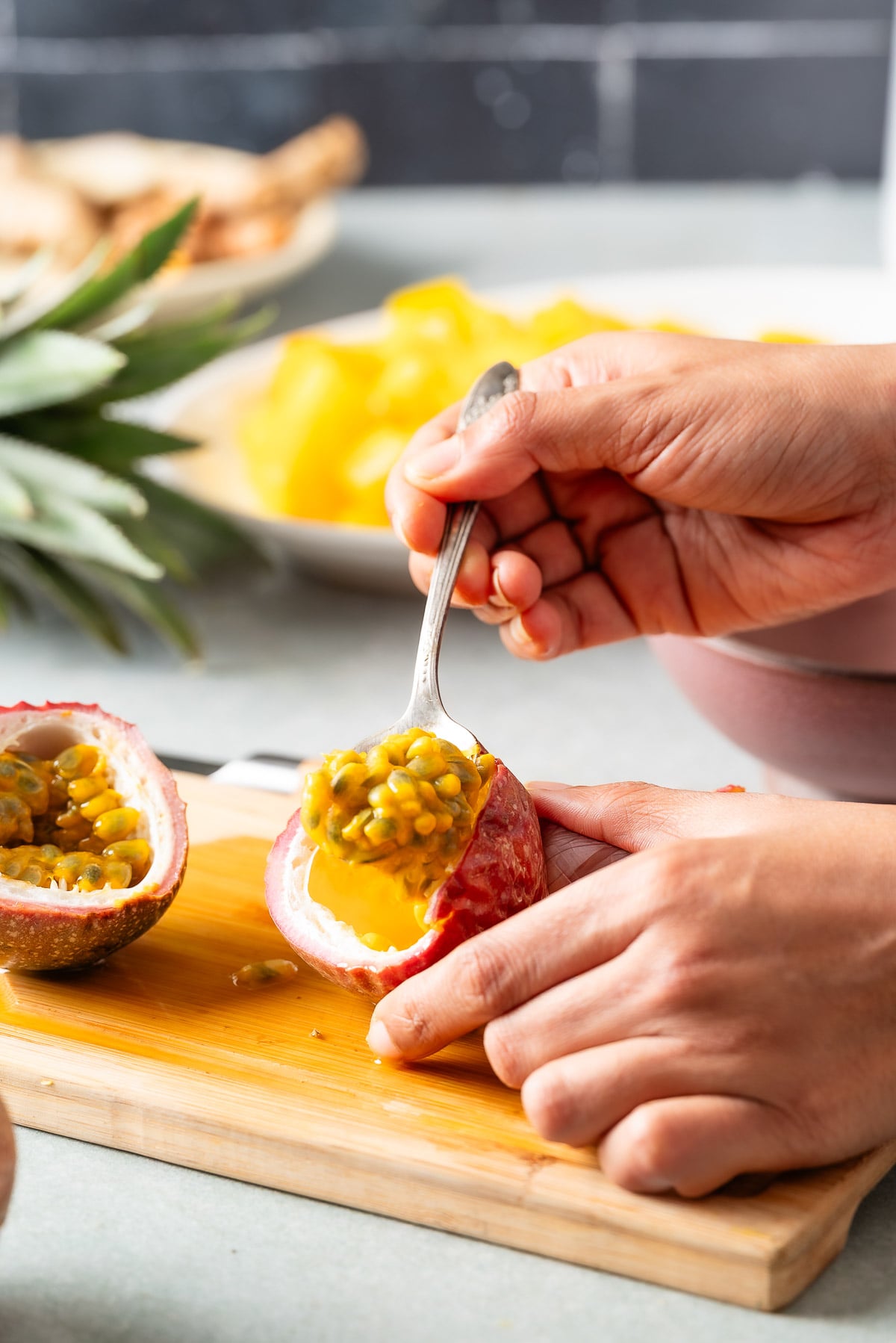Scooping out pulp and seeds of passionfruit