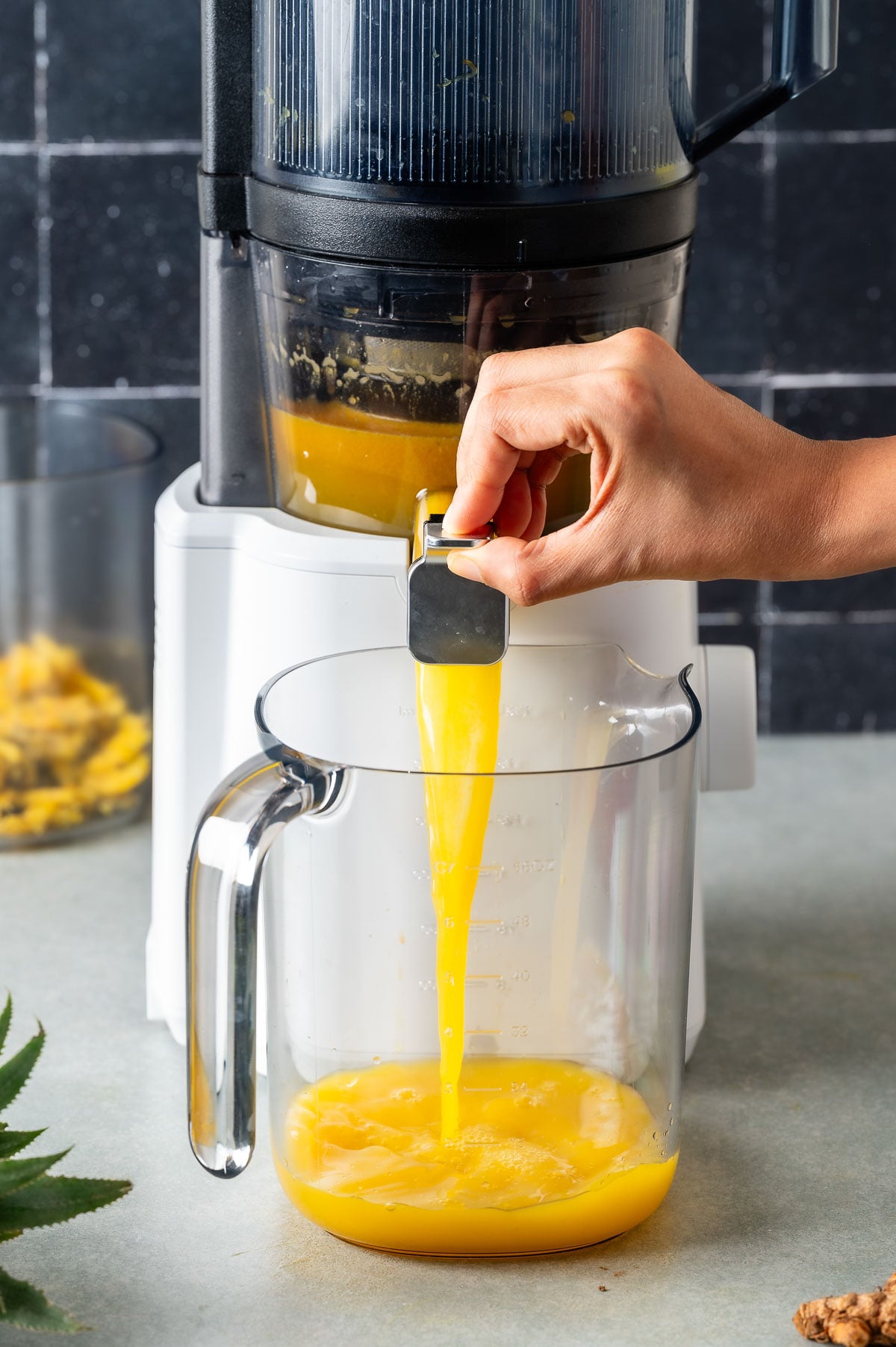 Fresh anti-inflammatory golden juice pouring into a container