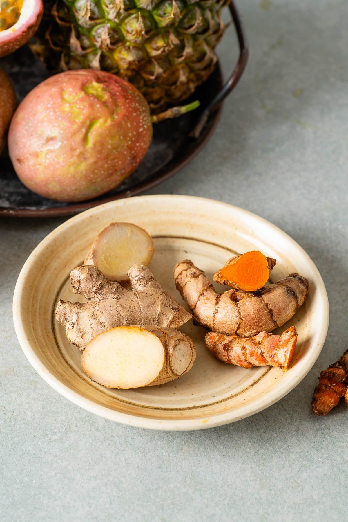 Fresh turmeric and ginger root placed on a plate