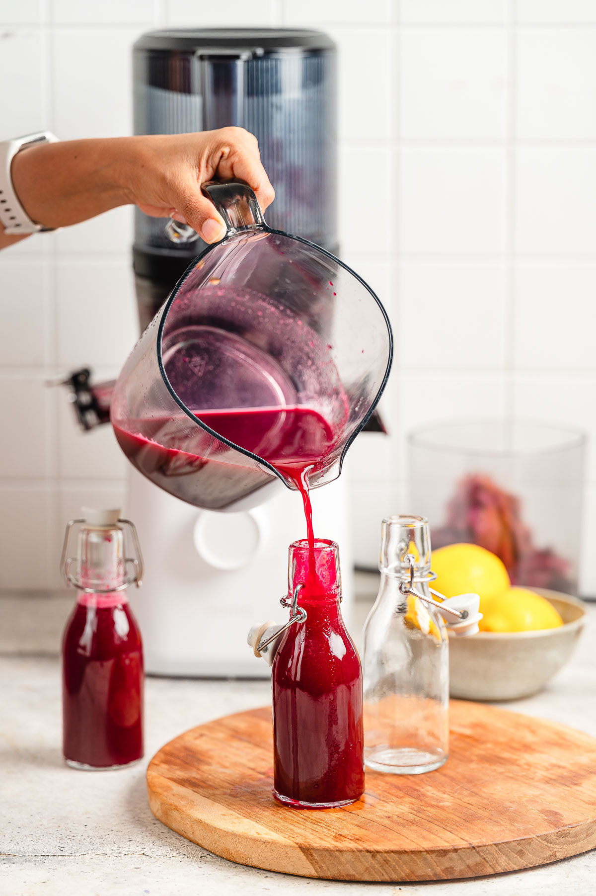 Pouring vibrant red juice in a bottle