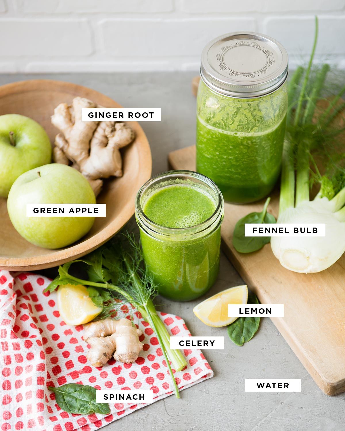 ingredients for a celery smoothie including ginger root, green apple, fennel bulb, lemon, celery, spinach and water.