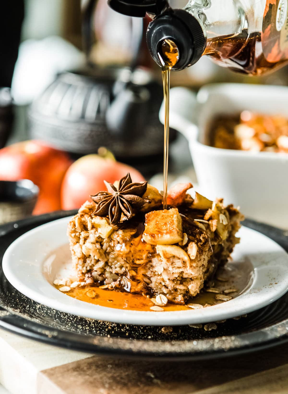 Baked oatmeal with cinnamon apples and syrup drizzle on top.