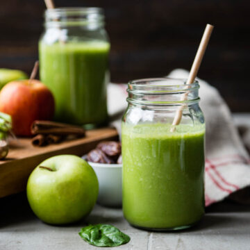 glass jar of warm apple pie smoothie surrounded by fresh ingredients