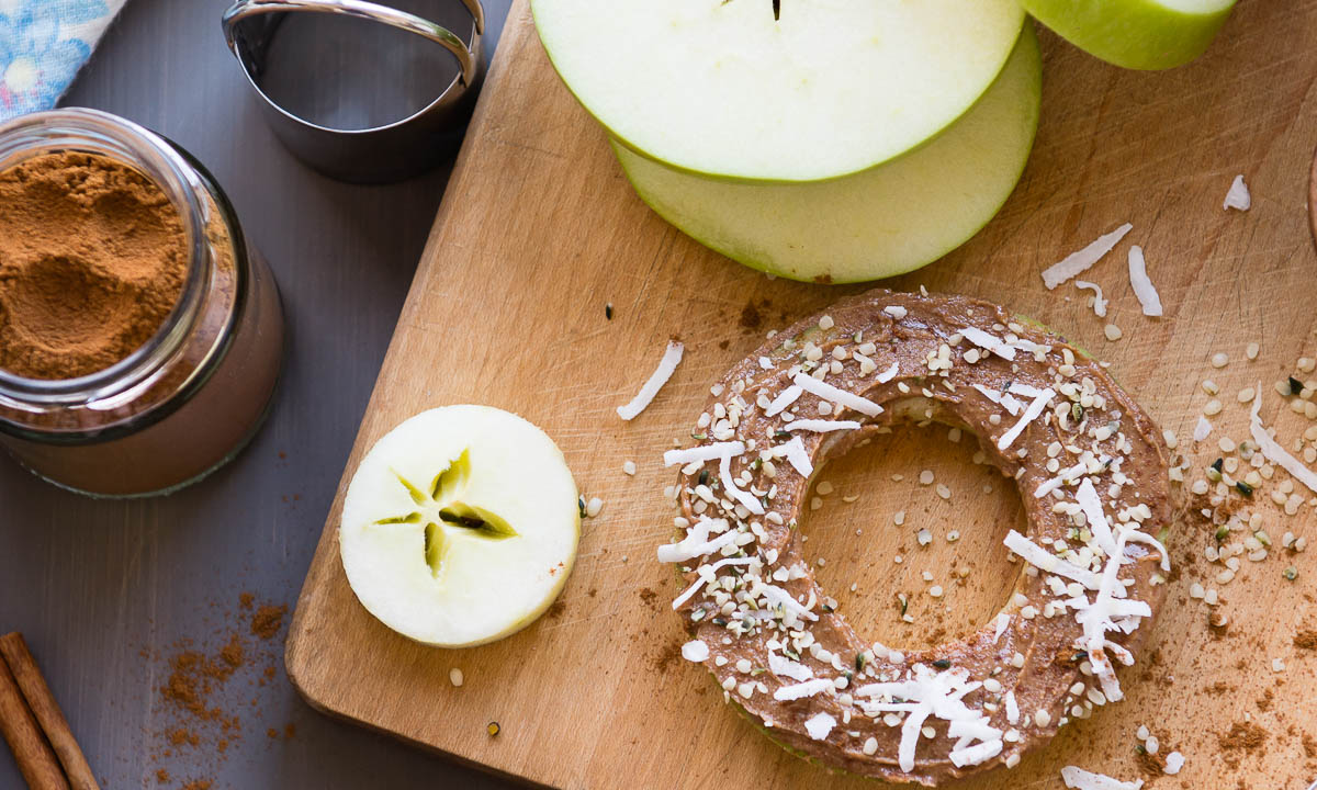 apples with the center cut out and topped with hemp seeds and coconut flakes.