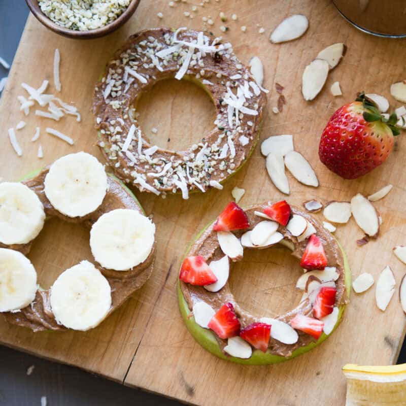 apple snacks topped with fresh fruit, nut butter and coconut flakes.