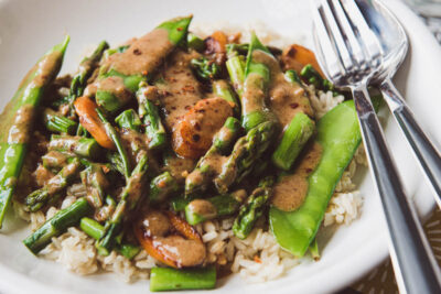 Asparagus stir fry recipe on plate with rice.