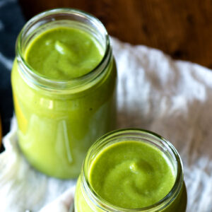 Glasses of avocado banana smoothie on table.