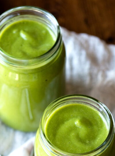 Glasses of avocado banana smoothie on table.