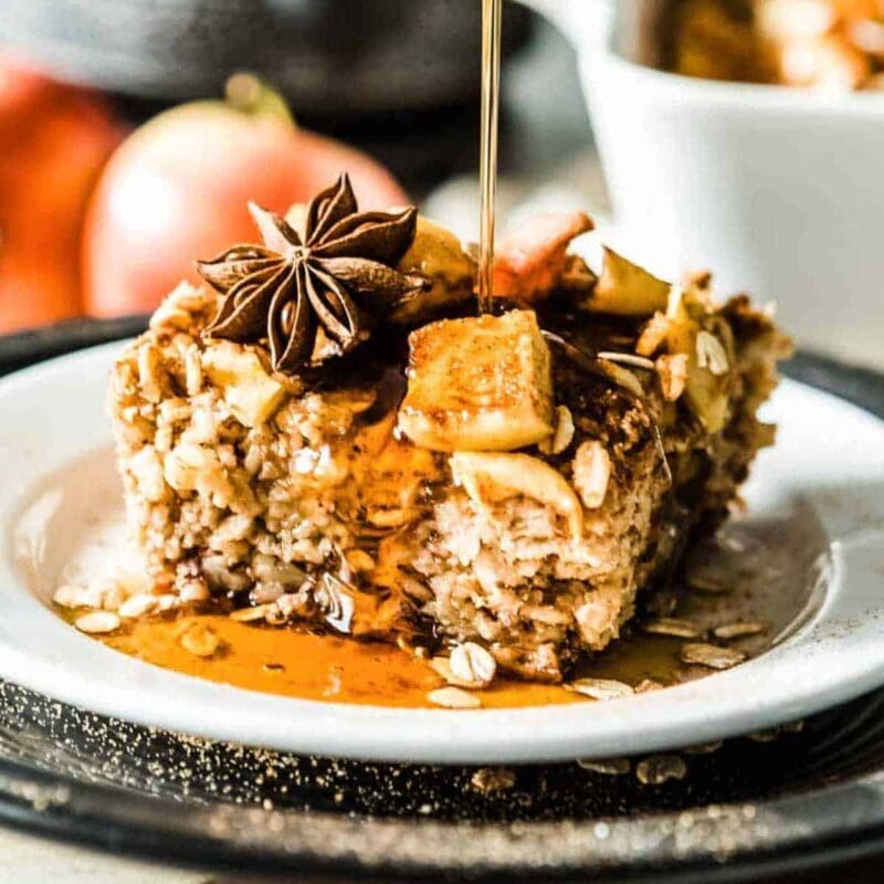Syrup pouring onto a slice of apple cinnamon baked oatmeal.