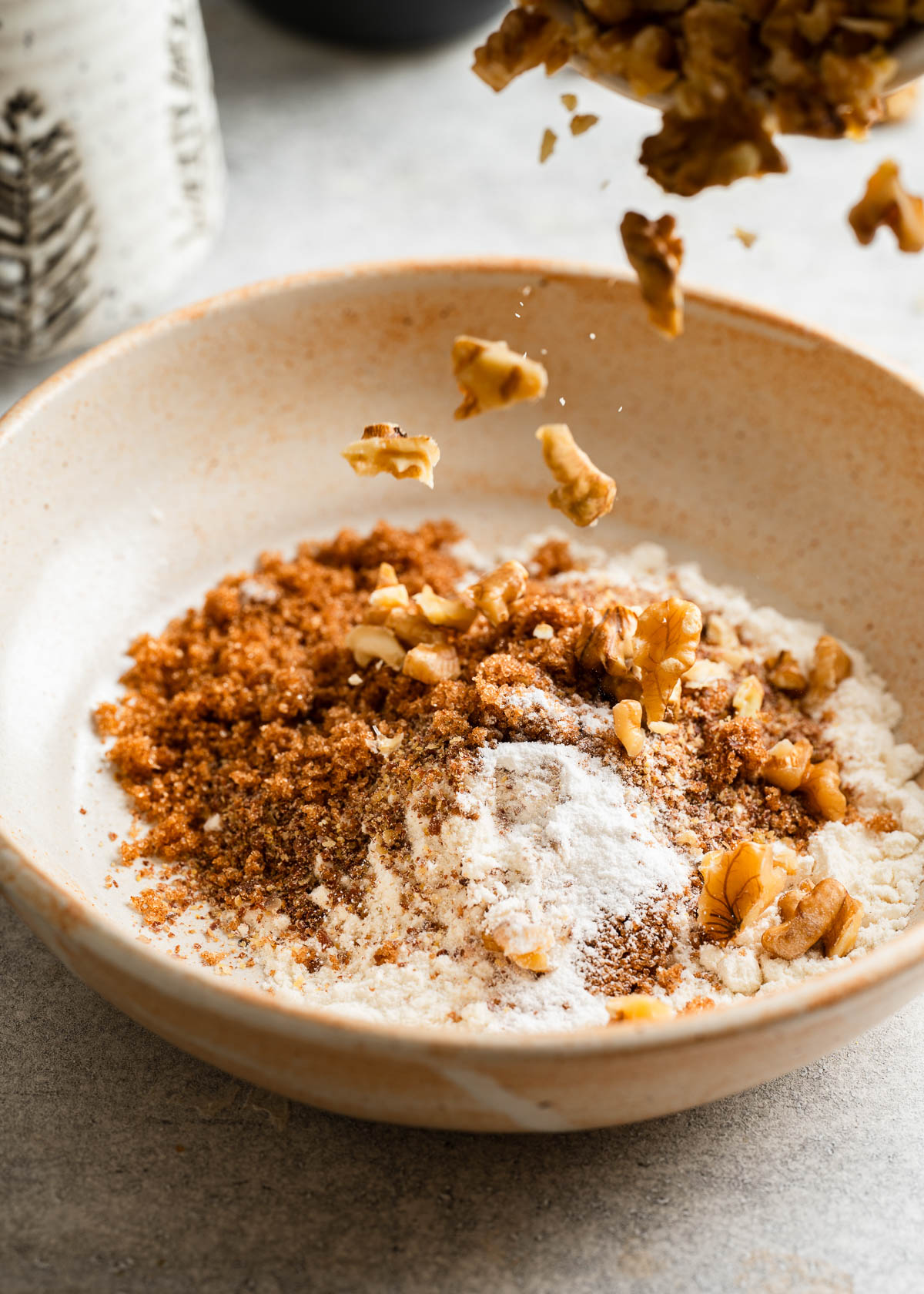 Ingredients for a banana mug cake recipe being layered in a bowl.