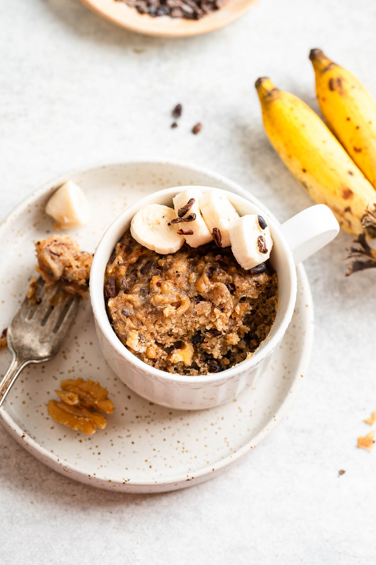 Top-down view of a banana mug cake decorated with banana slices.