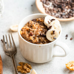 Banana mug cake garnished with slices of banana.