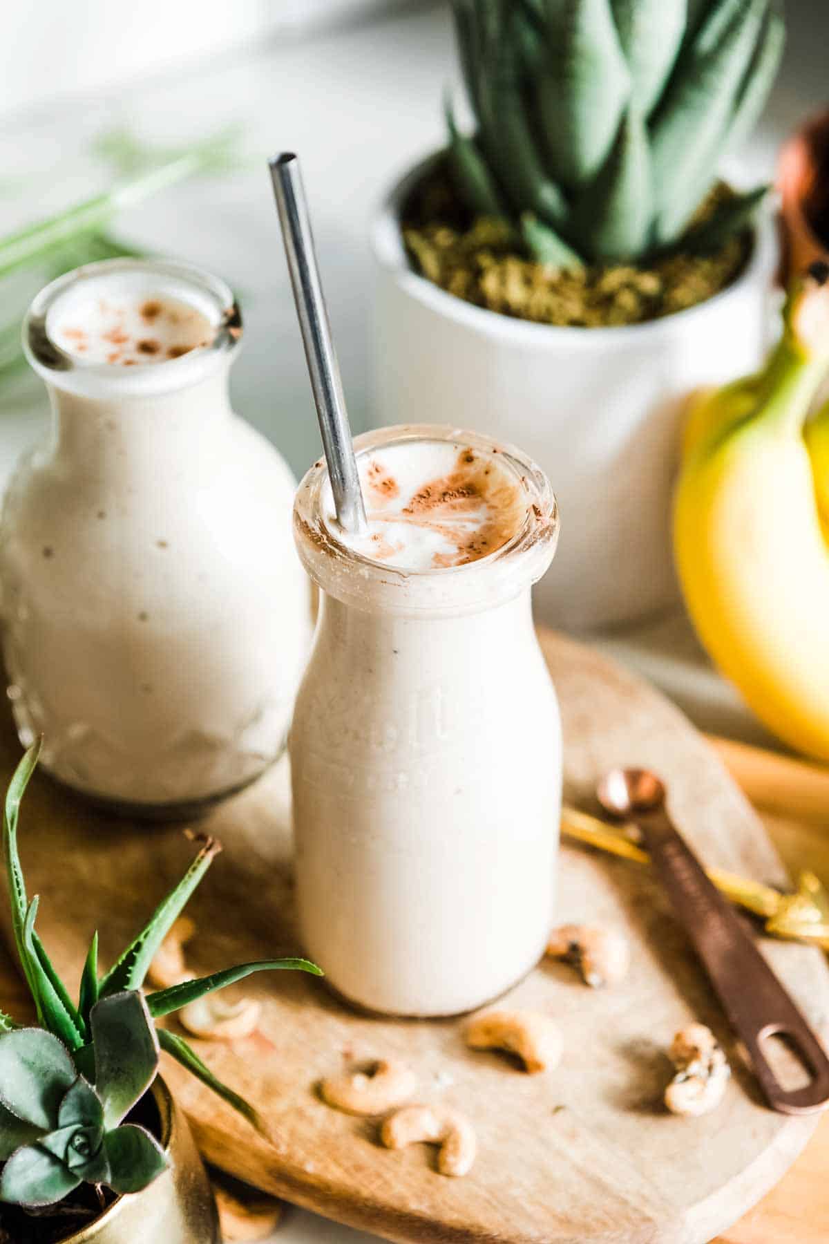 creamy smoothie in a glass with a metal straw.