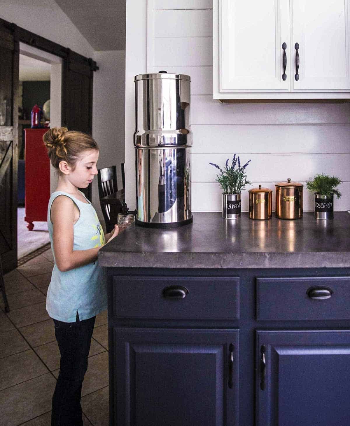 My daughter using our Berkey water filter system in the kitchen