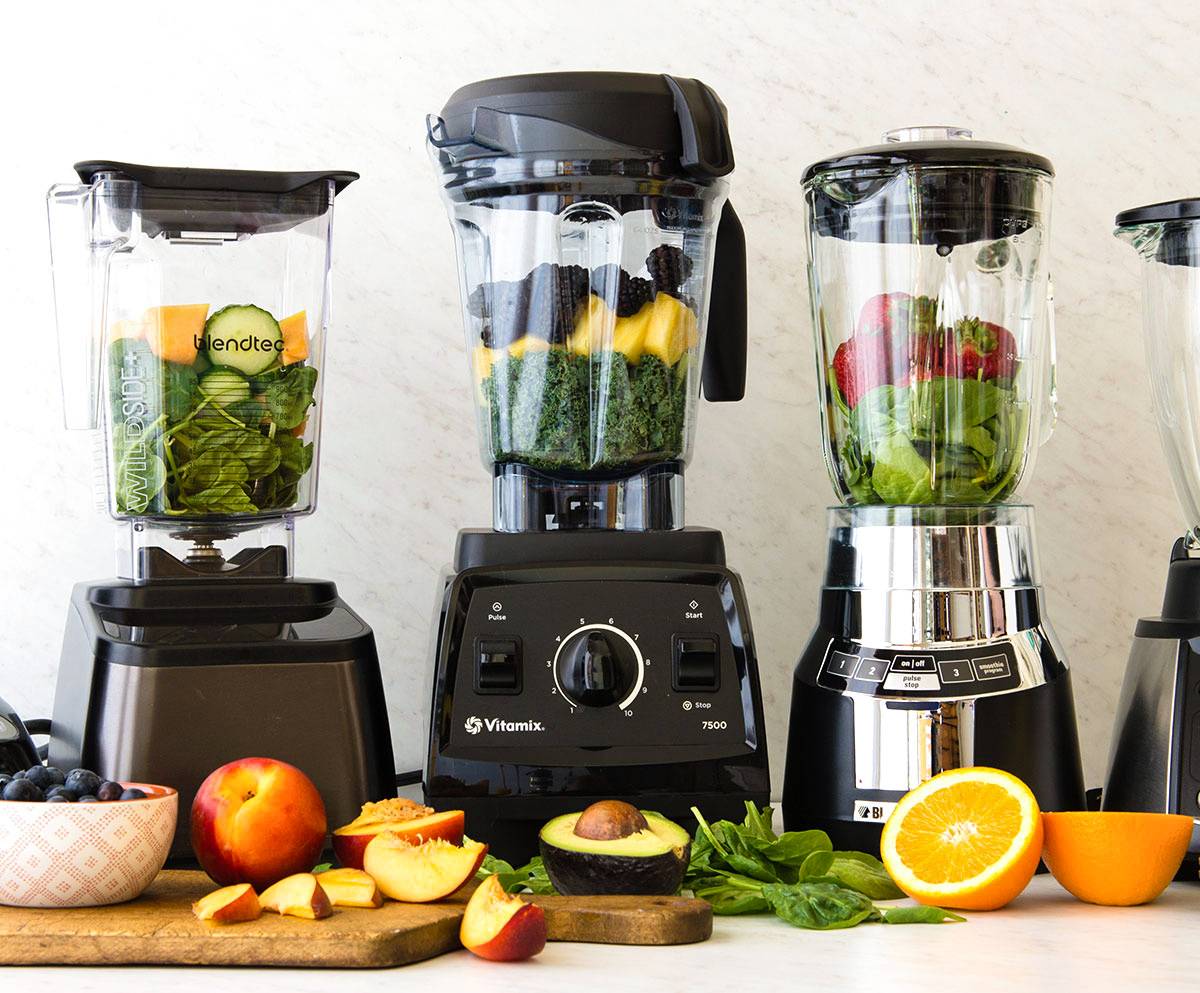 variety of blenders for smoothies with fresh fruit on counter