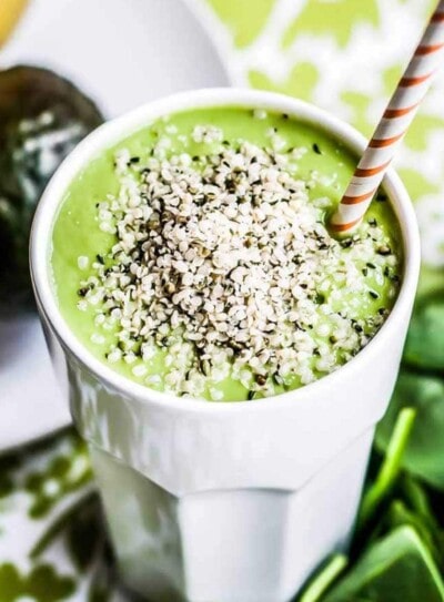 best brain food smoothie in white glass topped with hemp hearts and a paper straw.