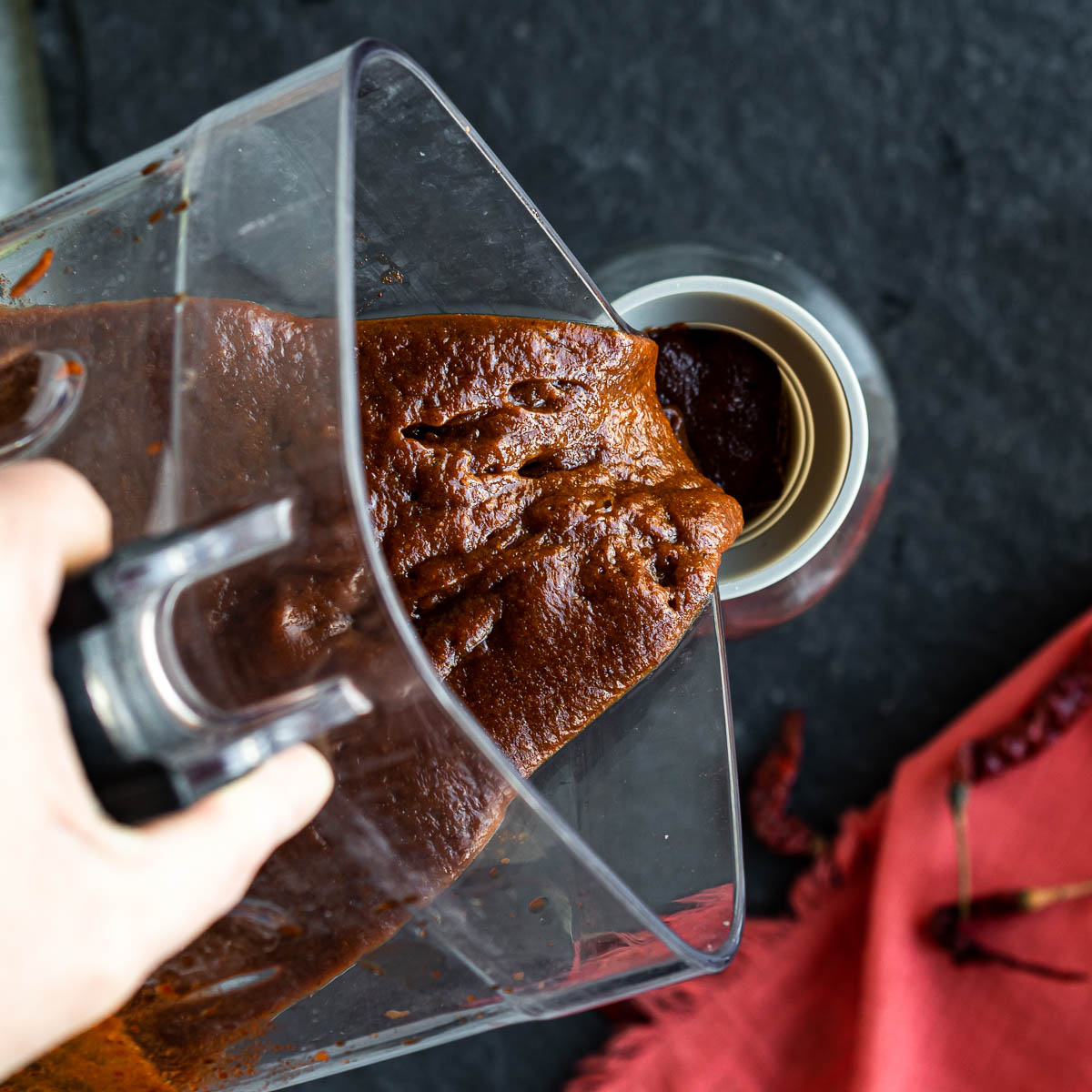 Transferring blended Chamoy sauce into a glass jar.